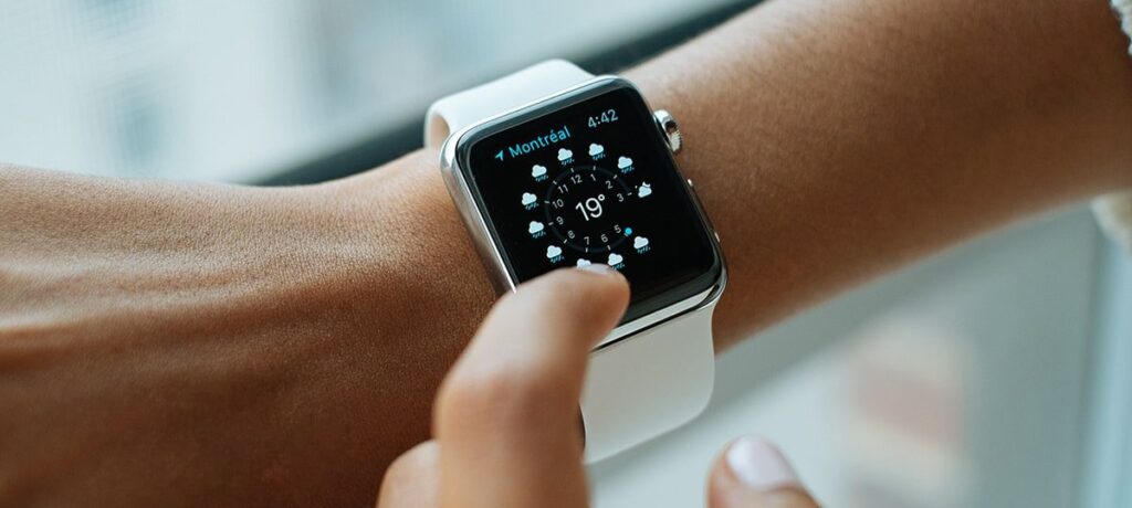 Woman's wrist wearing smartwatch showing weather.