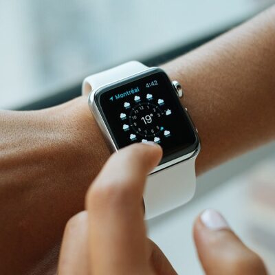 Woman's wrist wearing smartwatch showing weather.