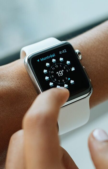 Woman's wrist wearing smartwatch showing weather.