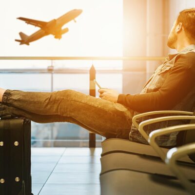 Man waiting at airport, feet up.