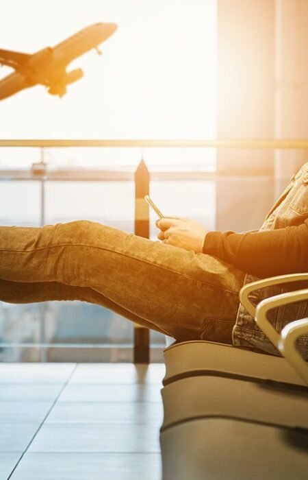 Man waiting at airport, feet up.