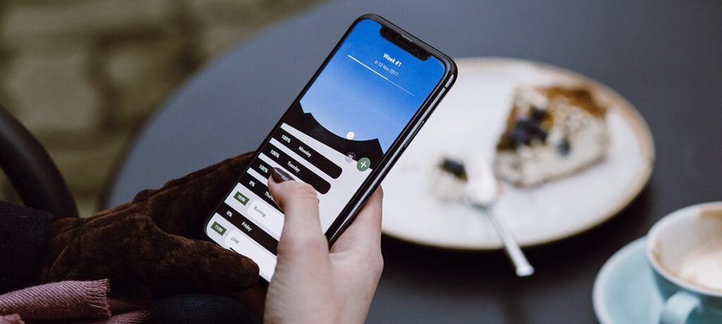 Person using weekly fitness tracker app.