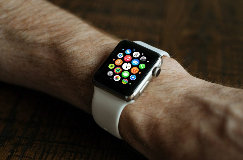 A person wearing an apple watch with various apps on it.