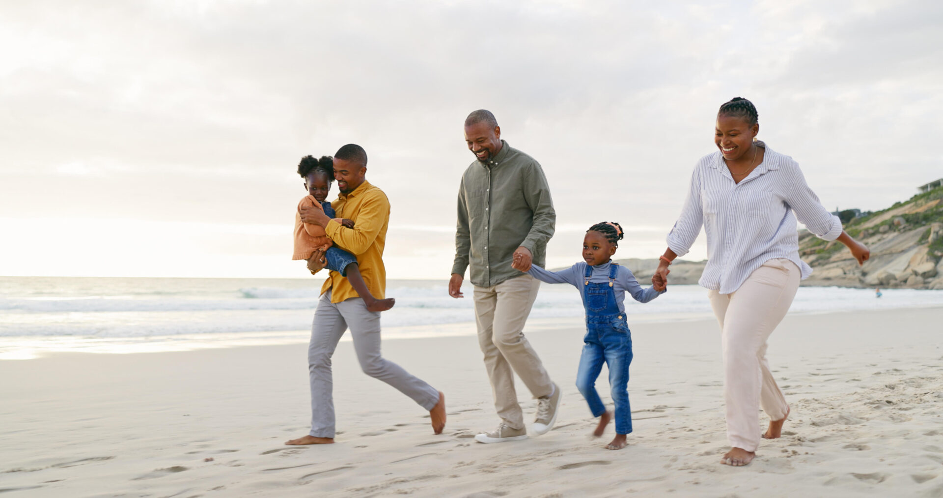 Happy, walking and a black family at the beach, holding hands and talking on a holiday. Sunset, conversation