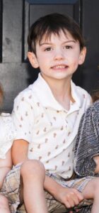 Smiling boy in pineapple shirt.